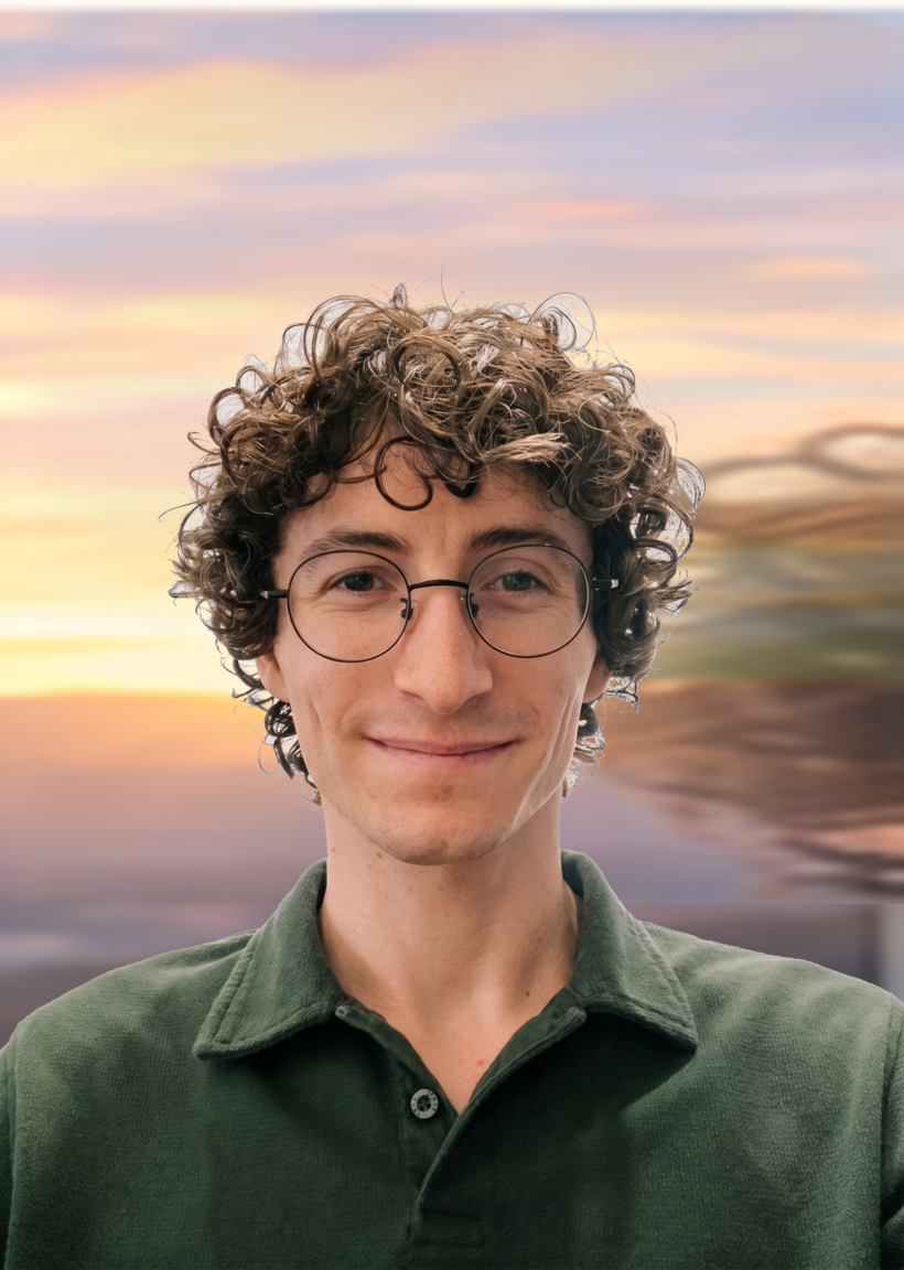 Josh Freedman wearing a dark green collared shirt in front of a mountain sunset